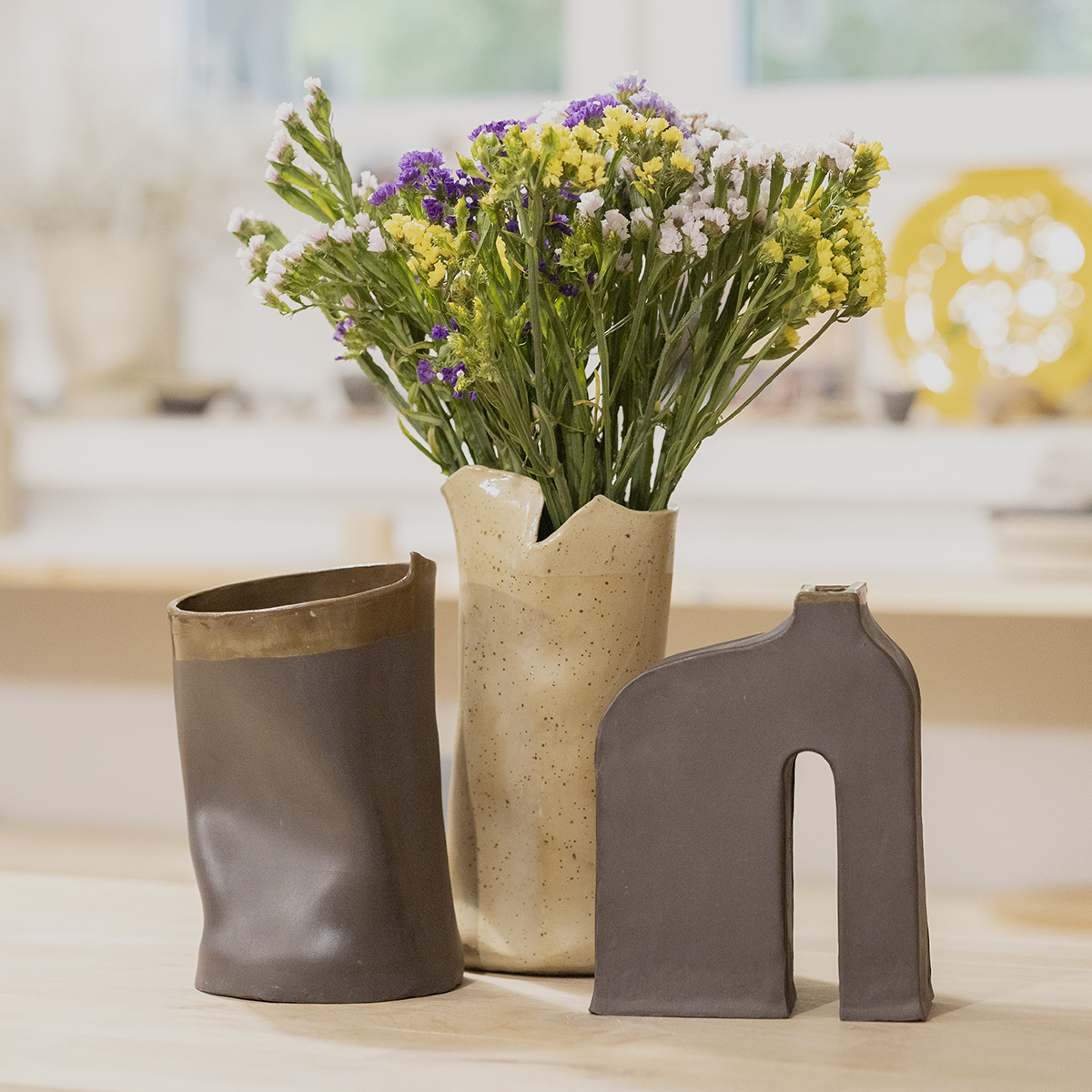 Trzy ceramiczne wazony z jesiennym bukietem kwiatów